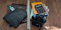 Group shot showing both leather portfolios, notebooks, clipboard, calculator, kraft paper roll and Chinon binoculars with case