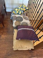 Stack of assorted pillows on floor showing all designs