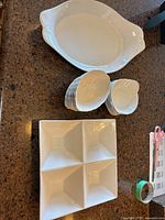 Group shot showing oval serving dish, two stacks of small dishes, and square four-compartment dish