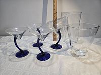 Group shot of four martini glasses and two vases with ruler for scale
