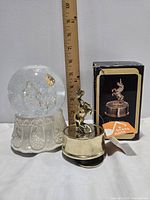 Snow globe, brass unicorn music box, ruler for scale, unicorn box