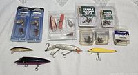 Overall lot showing packaged lures, treble hooks packs, tackle box, loose lures