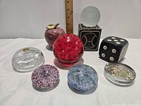 Group shot of all eight paperweights showing variety of materials and shapes