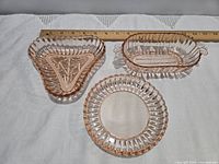 Top view of all three pink Depression glass dishes next to ruler