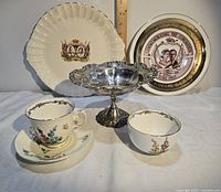 Overall view of all items: two commemorative plates, Staffordshire tea pieces, silver pedestal dish