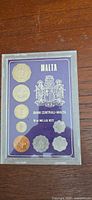 Front of sealed presentation set showing seven coins and Central Bank of Malta crest
