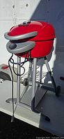 Full view of red Char-Broil electric grill on gray pedestal base