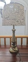Full view of table lamp on wooden surface showing base, column, shade