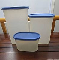 Three Tupperware containers grouped to show size differences and lids