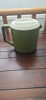 Full view of avocado green Rubbermaid pitcher with lid
