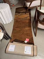 Full length view of one unrolled runner rug with second rug rolled beside