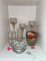 Six clear glass pieces arranged on shelf