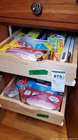 Open kitchen drawers showing multiple boxes of food-storage bags and wraps