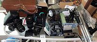 Overview of lot showing Canon camera, lenses, flash, tripods, digital cameras and accessories on table