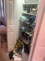 Closet shelves showing blankets, Omron box, hangers, bags, hair dryer