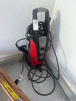 Full view of red and black Husky 1800 pressure washer with cords