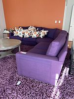 Full sectional sofa against orange wall with throw pillows