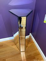 Front view of triangular mirrored pedestal positioned in corner