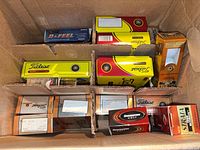 Open shipping carton containing multiple retail golf ball boxes of various brands