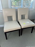 Both cream keyhole-back chairs front view