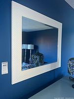 Full view of mirror mounted on wall above dresser