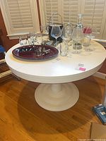 Full view of white round pedestal dining table with items on top