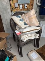 Stacked wicker chairs with pillows on seat