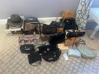 Wide shot of all bags, pouches and hats on carpet