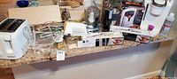 Countertop view showing toaster, organizers, boxed slicers, coffee makers, accessories