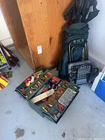 Overall lot showing tackle box open with lures, folded camp chair and utility cart