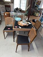 Card table with four matching cane-back chairs