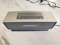 Front view of Bose SoundLink Mini speaker showing grille and top control panel