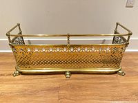 Overall view of brass fireplace fender front and side