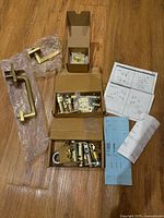 All components laid out including exterior grip, interior lever, hardware boxes, instructions