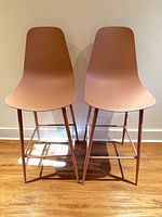Front view of both pink bar stools showing overall design and color