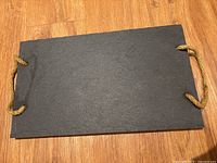 Top view of full stone board showing rope handles at both ends