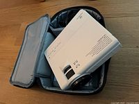 Vankyo projector inside open carrying case showing lens and top controls with cables