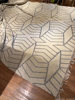 Full view of rug showing geometric pattern and fringe