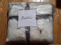 Front view of factory-sealed Battilo faux fur throw with brand card
