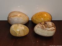 Group shot of four polished stone eggs in varied colours