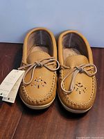 Top view of both moccasins showing beaded toes and tag