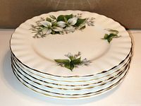 Stack of six Royal Albert Trillium salad plates showing gold trim and floral design