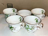 Four teacups and one sugar bowl grouped