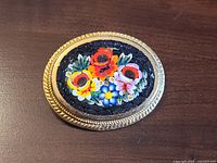 Front view showing floral micro mosaic and gold-tone frame