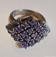 Front view showing purple stone cluster and perimeter accents