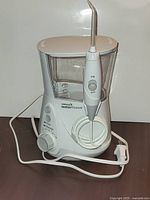 Front view showing Waterpik WP-660 unit with handle, dial, hose and cord