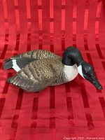 Full side view of Canada goose sculpture on red background
