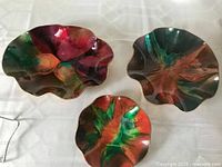 Three multicolour ruffled glass trays displayed