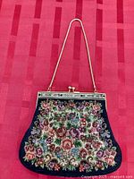 Front view showing floral petit point, frame, chain