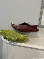 Burgundy and green ceramic dishes displayed on shelf